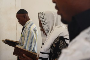 Peter Agbai (in the middle) an elder in a synagogue in Nigeria, joins men in a Shabbat service
