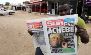 A Nigerian reads a newspaper featuring a headline on Chinua Achebe's death on 22 March. Photograph: Pius Utomi Ekpei/AFP/Getty Images