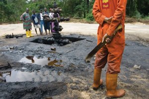 Scenes in Oloibiri Town, Niger Delta. An oil spill from an abandoned Shell Petroleum Development Company well in Oloibiri, Niger Delta.  Wellhead 14 was closed in 1977 but has been leaking for years, and in June of 2004 it finally released an oil spill of over 20,000 barrels of crude. Workers subcontracted by Shell Oil Company clean it up.