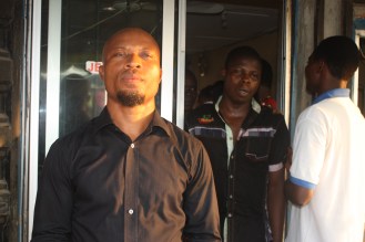 Bassey Ngehaje AKA Mr. Condom, stands in front of his shop in Eket