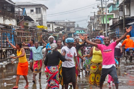 People celebrate Saturday on the streets of the West Point slum area in Monrovia, Liberia, after the quarantine was lifted. The slum was once sealed off by security forces in August 2014 in an attempt to control the Ebola outbreak. (Abbas Dulleh/AP)