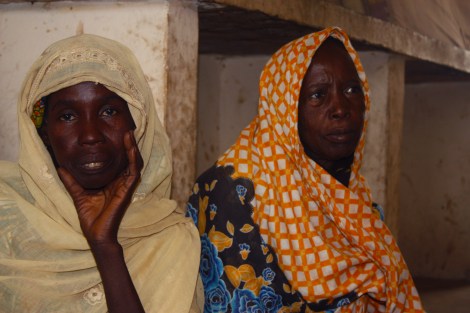 Isa Bukar, 50, fled Bama after Boko Haram insurgents killed her husband in the southern Borno town of Bama. Isa Jibrin, 60, does not know whether her husband is alive. Both women stay in a camp for displaced people in the Borno State capital of Maiduguri in northeastern Nigeria. Photo by Chika Oduah. Maiduguri, Nigeria.  December 16, 2014.