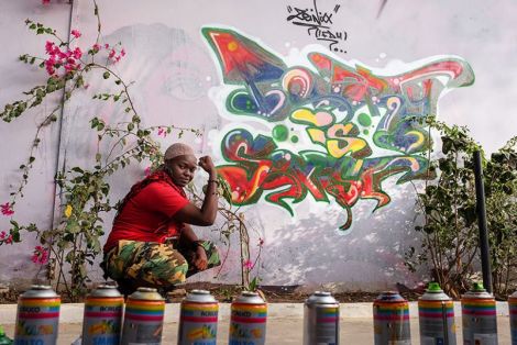 Dieynaba Sidibe strikes a #strengthie pose next to her artwork of our “Poverty Is Sexist” slogan at a hip-hop artists’ center in Dakar, Senegal. (Photo: Ricci Shryock/ONE)