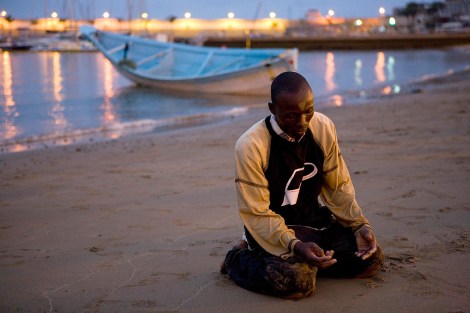 July 1, 2008: A man offer prayers of thanks after arriving at a beach on Spain's Canary island of Gran CanariaBorja Suarez/Reuters Mediterranean migrants