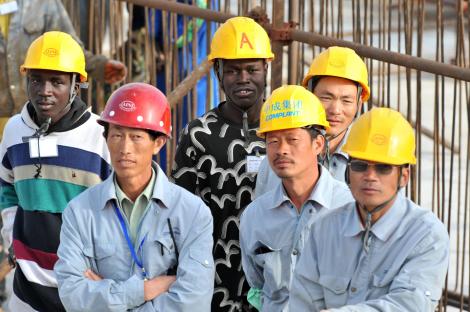 Senegalese and Chinese workers observe a ceremony at the national theater construction site financed by China on February 14, 2009 in Dakar, during a visit by Chinese president Hu Jintao and Senegalese president Abdoulaye Wade. AFP Photo / SEYLLOU_24 FEB 2013 