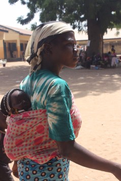 Rose, 25, carries 28-day-old Ibrahim on her back. The baby boy's twin brother was killed by Boko Haram insurgents the day he was born. The insurgents also killed his mother the same day. Yola, northeasern Nigeria. January 17, 2015. Photo by Chika Oduah