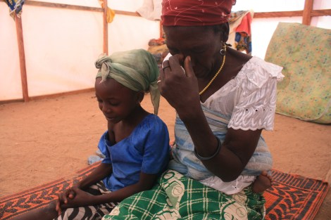 Jummai Joshua, 8-year-old orphan, prayers with her grandmother inside the tent they share in a refugee camp in Yola, northeastern Nigeria. She and her grandmother fled their village in January when Boko Haram fighters attacked, killing her father. January 17, 2015. Photo by Chika Oduah