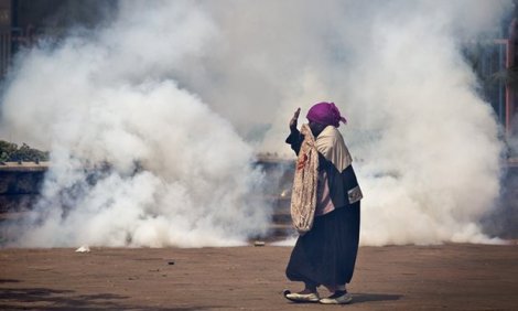 A woman caught up in the clashes holds her hands in the air as riot police approach amid clouds of teargas during a July 2016 protest in Nairobi. Photograph: Ben Curtis/AP