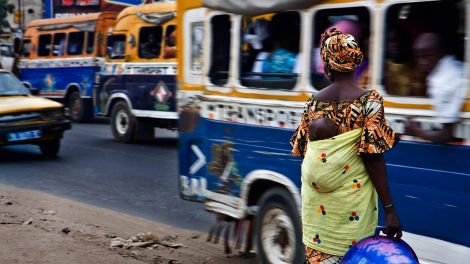 A woman stands on a busy street in Dakar, Senegal. Photo by Edgar de Bono